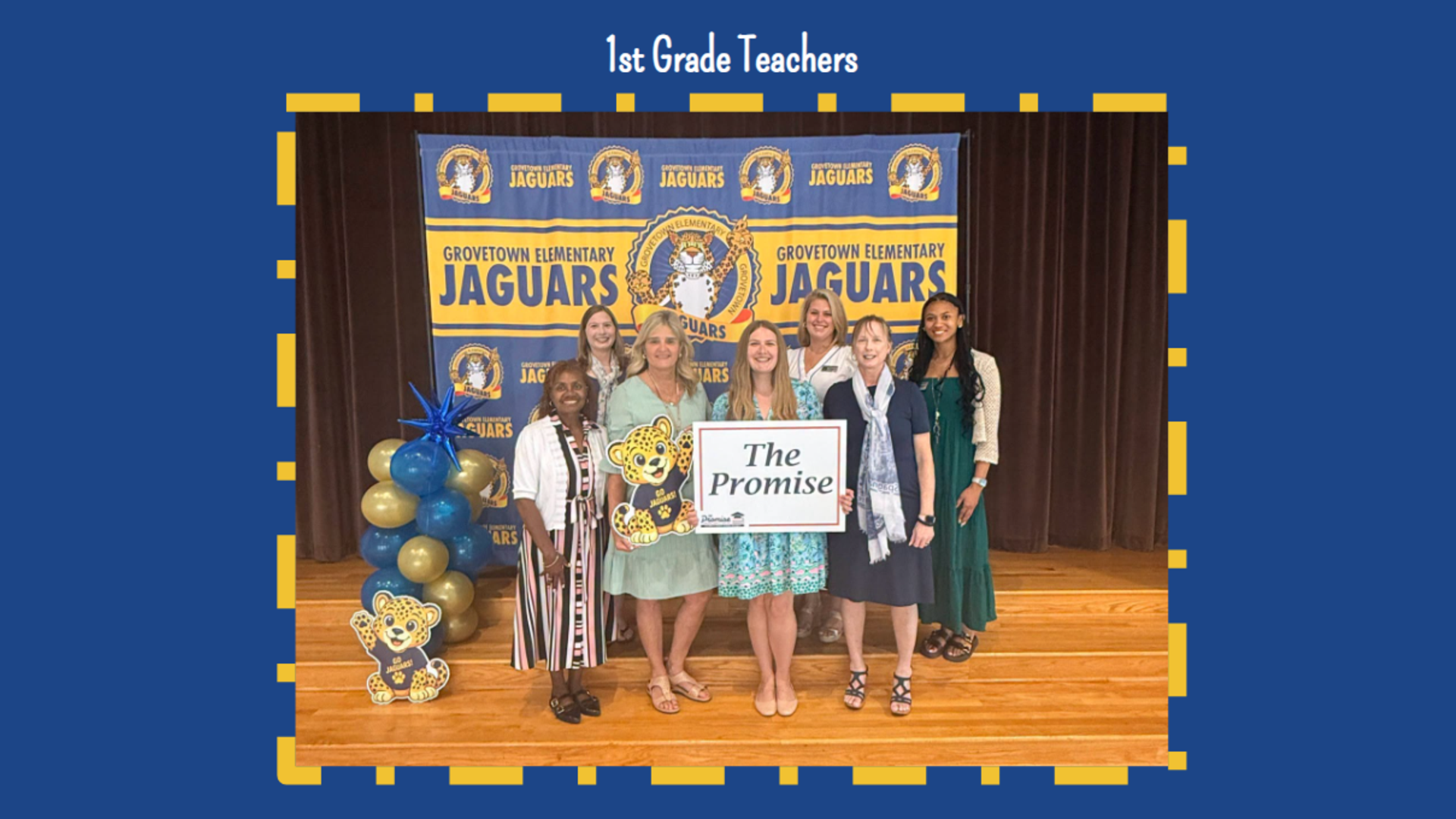 Group of first grade teachers posing in front of a school backdrop.