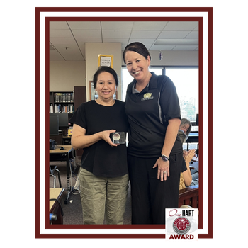 Photo of 2 women, 1 holding an award