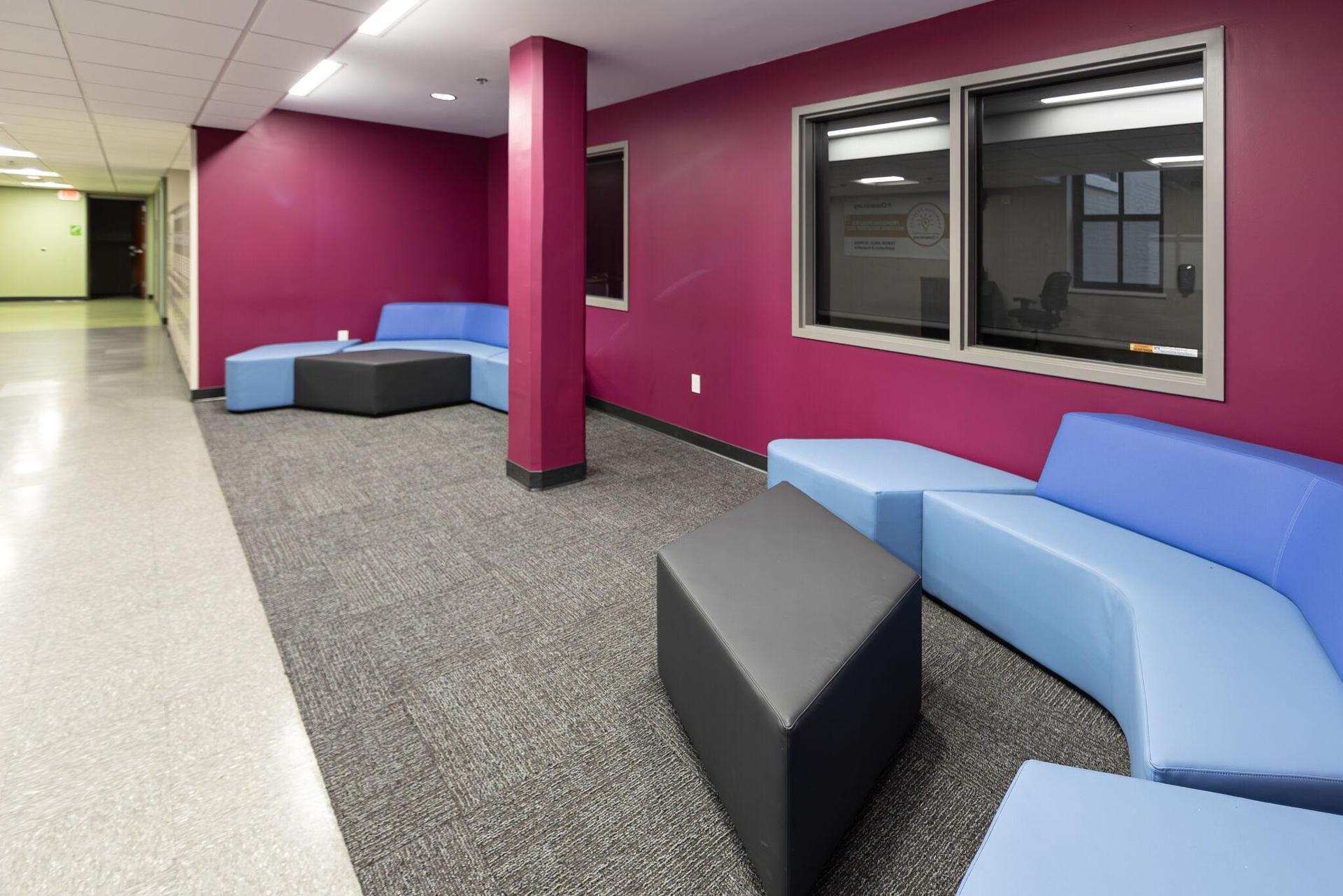 A new space for students to spend time together between or after classes. It has bright pink walls and blue couches.