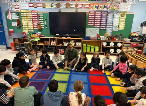 Children sitting in a circle in a music class.