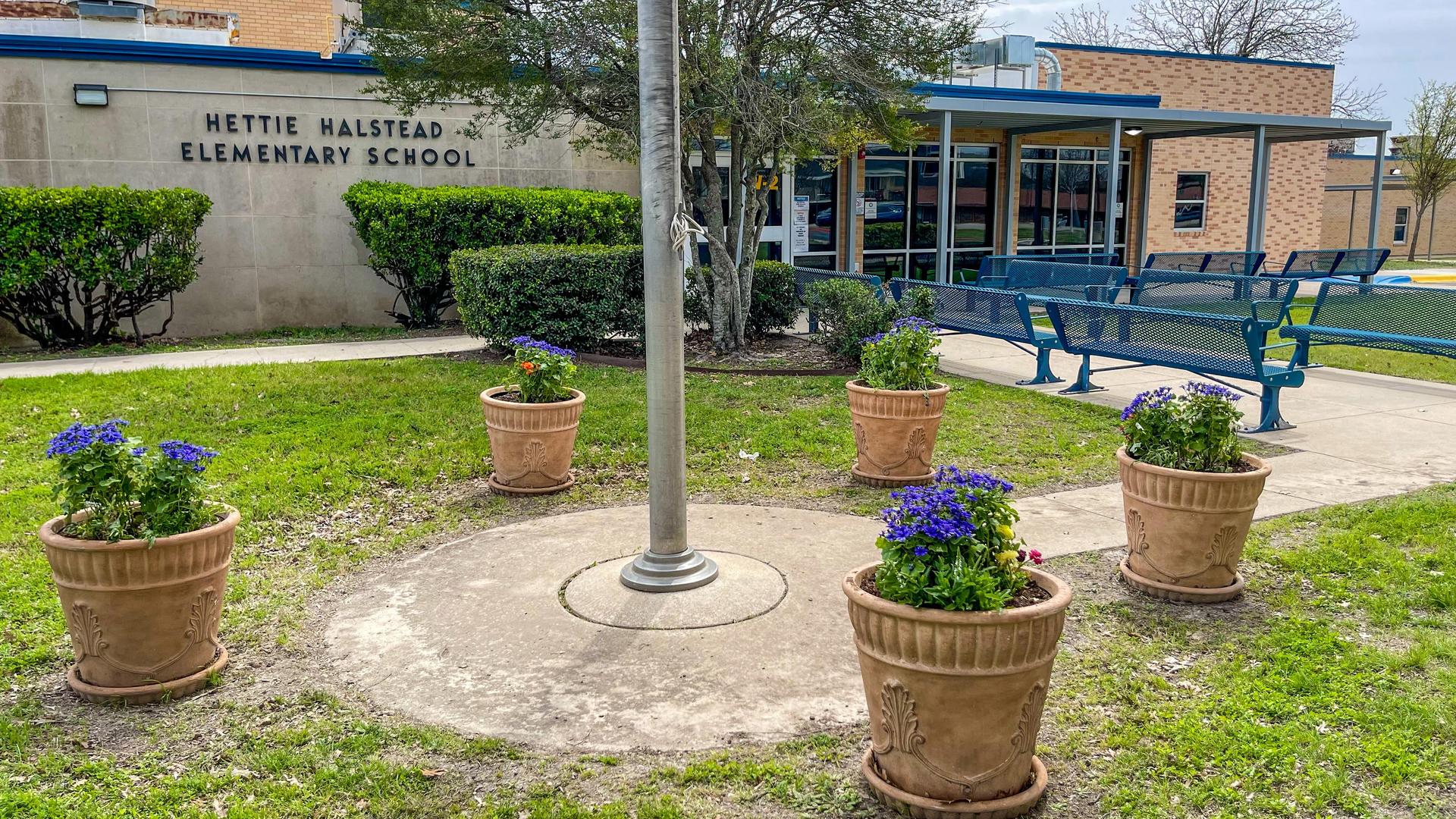 Front view of Hettie Halstead Elementary School with flower pots.