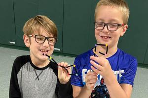 Third-graders Cyrus Vincent and Ben Gable show their finished crafts