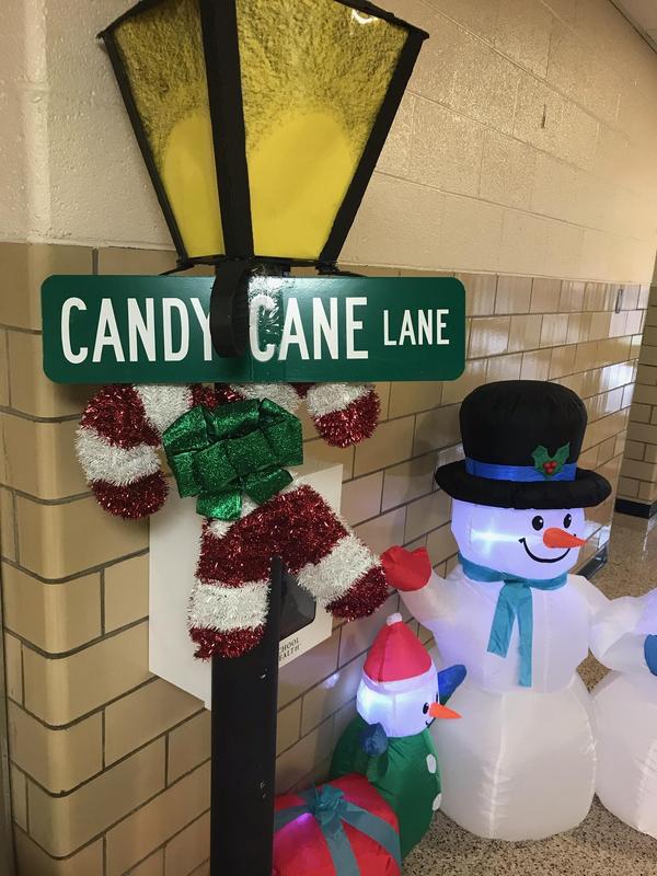 Inflatable snowman by lamp post with streetsign for