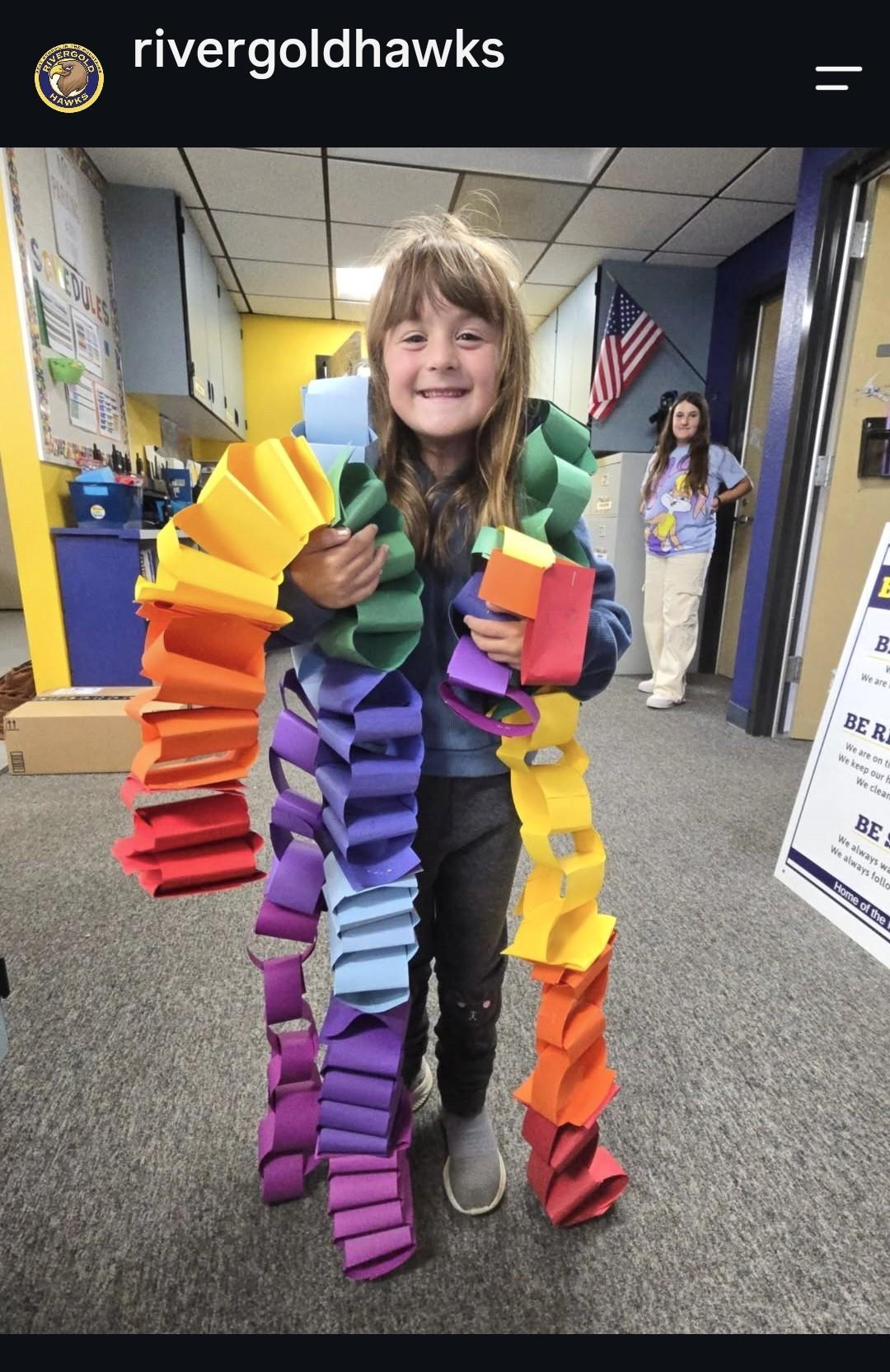 student with rainbow paper chain
